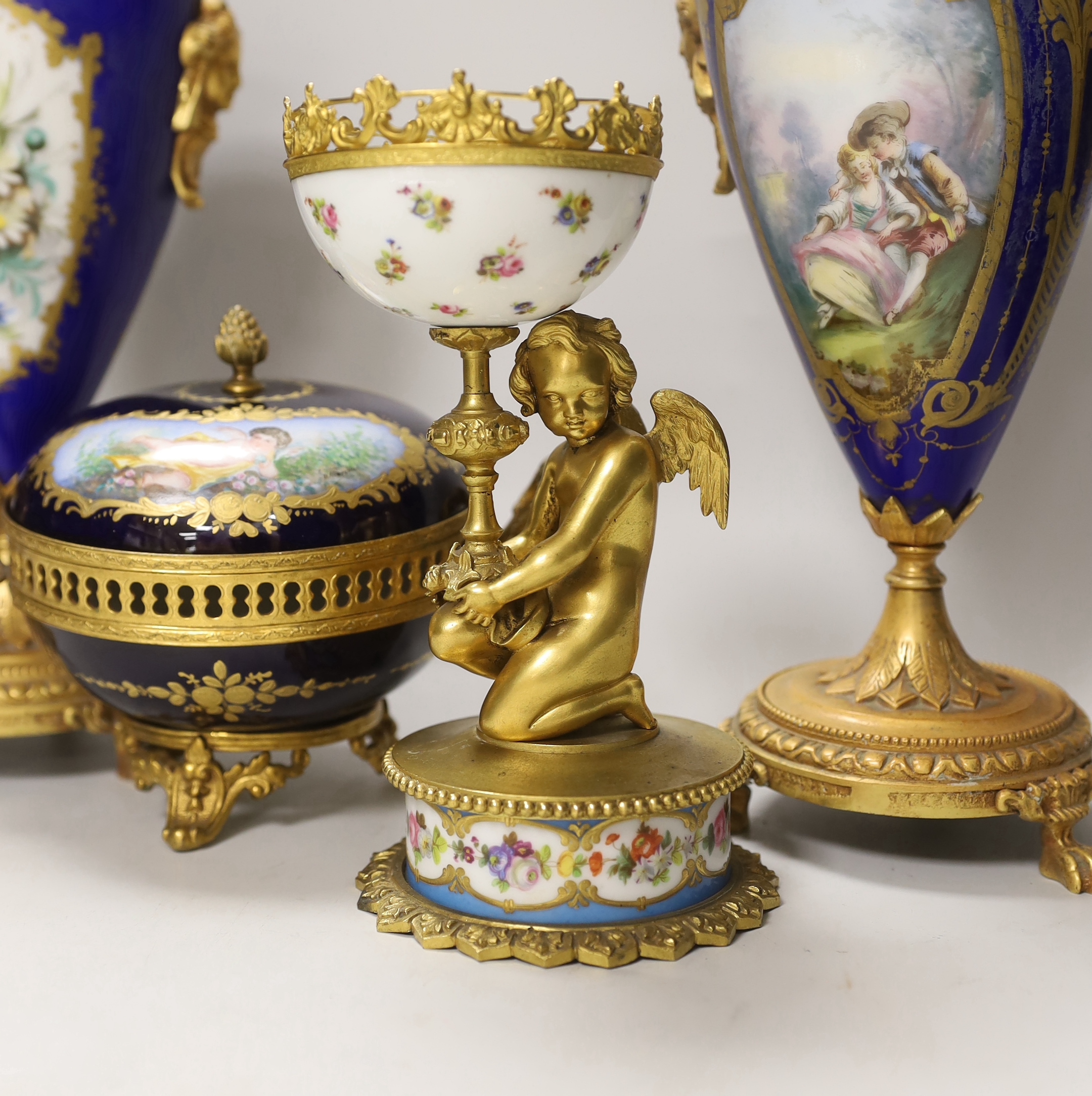 A pair of Sevres style porcelain ormolu mounted vases, a similar putti stemmed cup and a bowl and cover, tallest 27cm